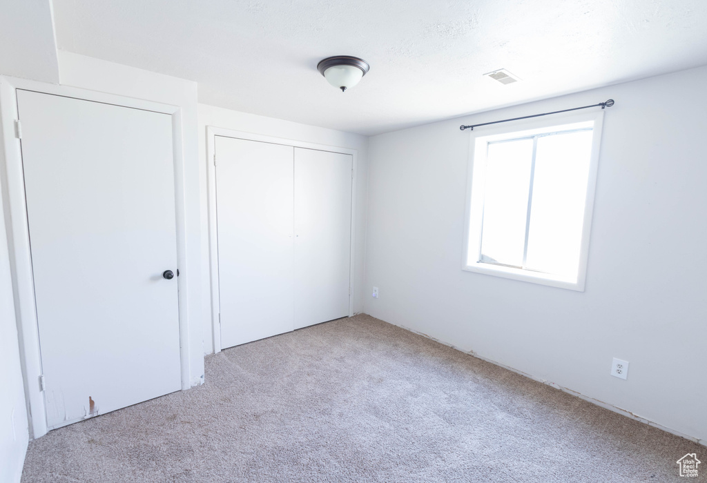 Unfurnished bedroom featuring carpet flooring and a closet