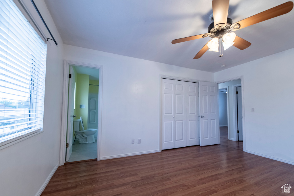 Unfurnished bedroom with wood finished floors and baseboards