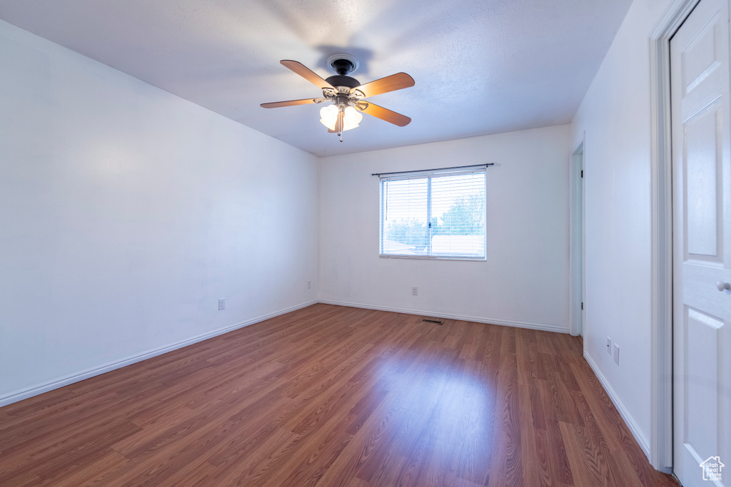 Unfurnished bedroom with wood finished floors, baseboards, and a ceiling fan