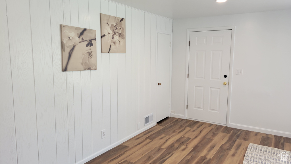 Spare room featuring wood finished floors, baseboards, wooden walls, and recessed lighting