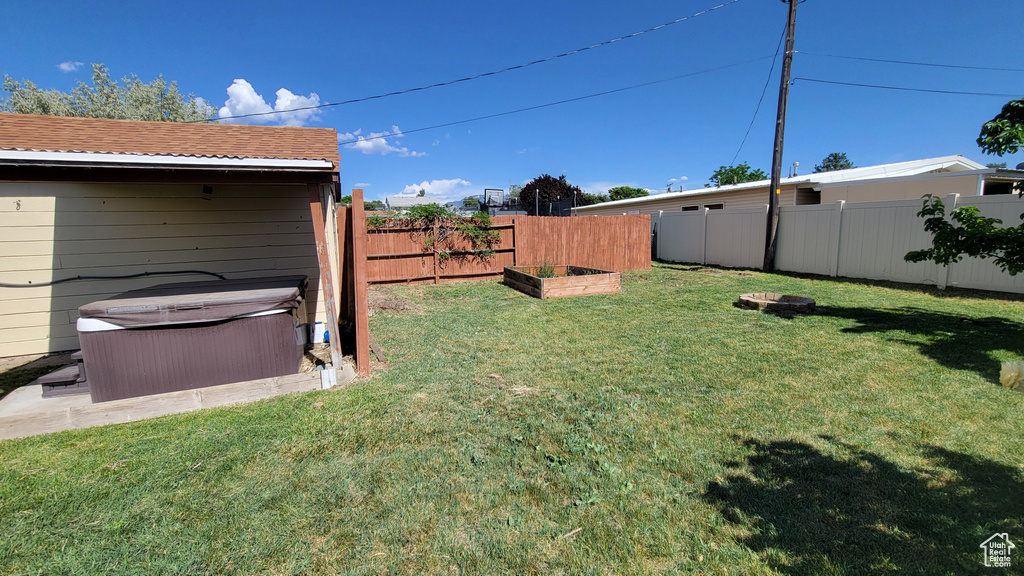 View of yard featuring a hot tub and a vegetable garden