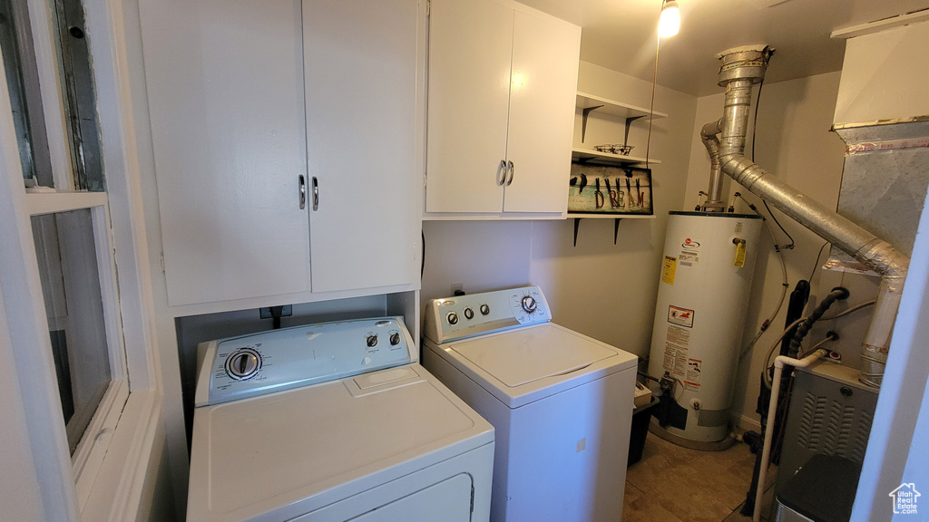 Laundry area with water heater, separate washer and dryer, and cabinet space