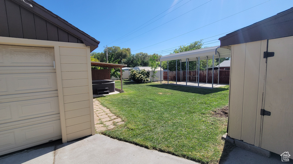 View of yard featuring a hot tub and a garage