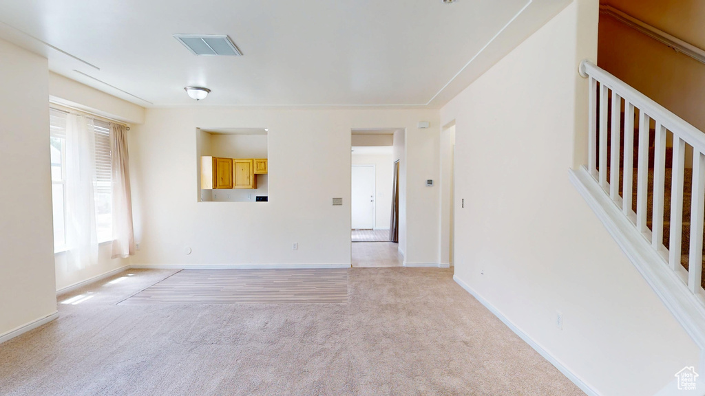 Unfurnished room featuring light colored carpet and baseboards