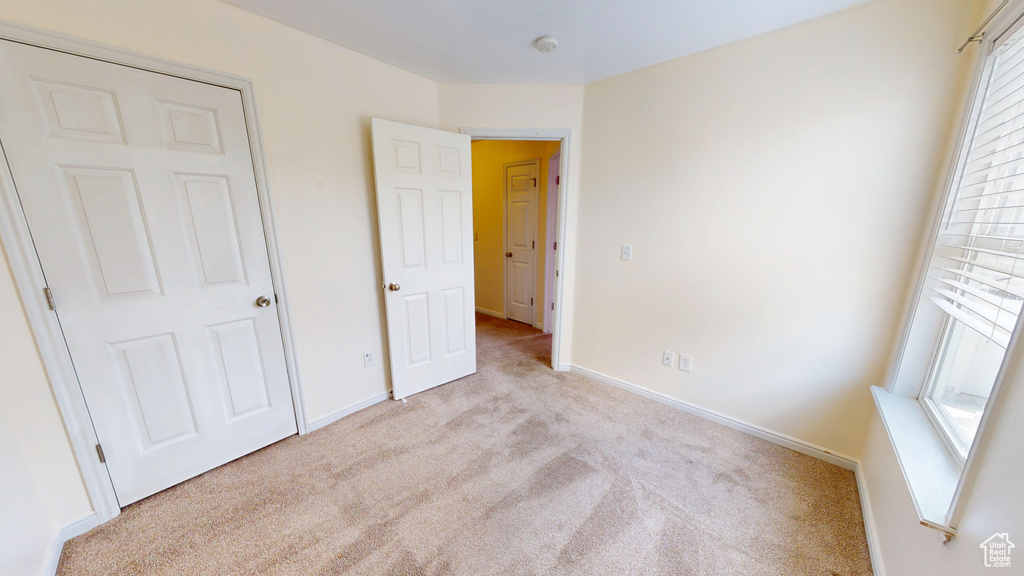 Unfurnished bedroom with carpet floors and baseboards
