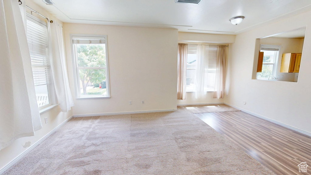 Carpeted spare room with plenty of natural light and baseboards