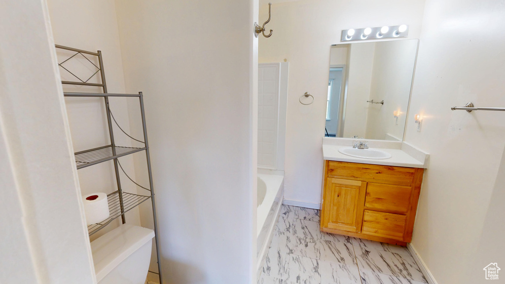 Full bathroom with marble finish floors, vanity, a bath, and toilet