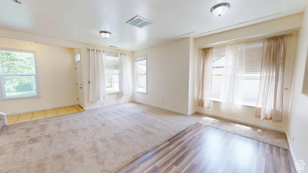 Carpeted spare room featuring baseboards