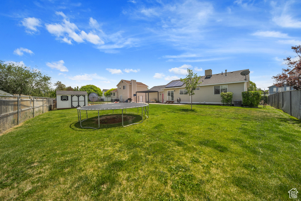 View of yard featuring a trampoline and cooling unit
