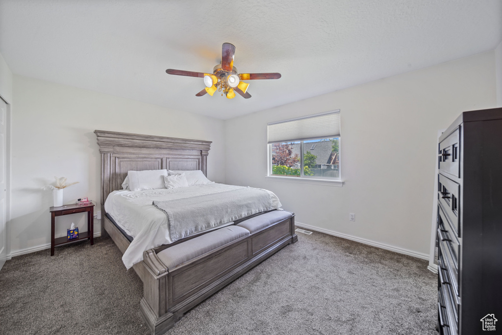 Carpeted bedroom featuring baseboards and a ceiling fan