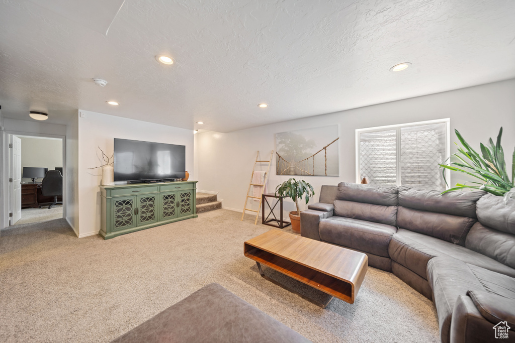 Living room featuring carpet, recessed lighting, stairway, baseboards, and a textured ceiling
