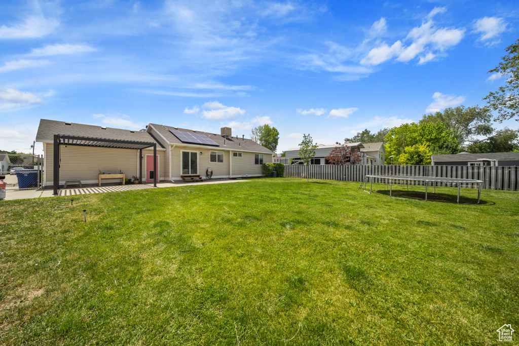 View of yard featuring a trampoline and a patio area