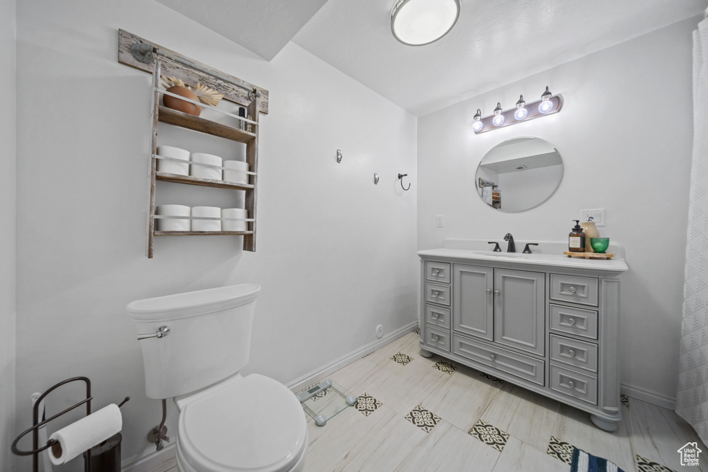 Bathroom with baseboards, vanity, and toilet