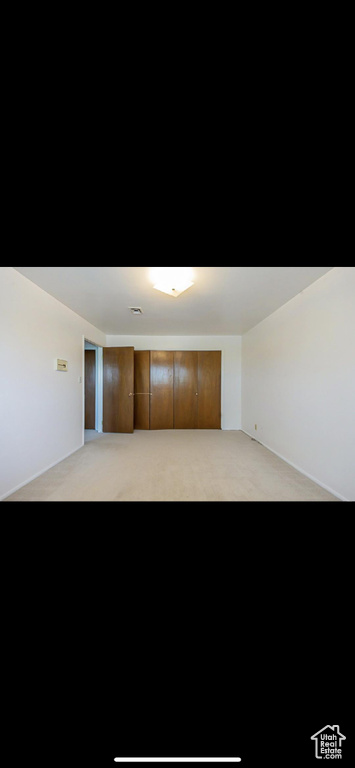 Empty room featuring light colored carpet