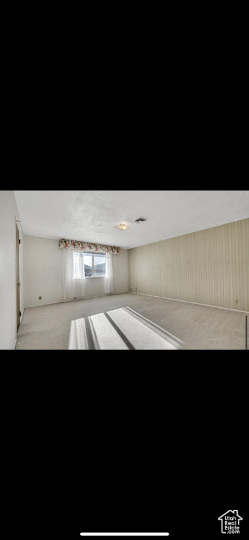 Unfurnished room featuring light carpet