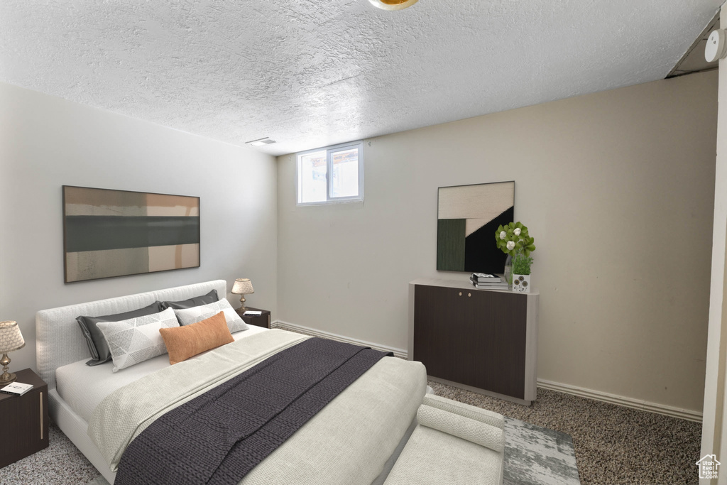Bedroom with carpet flooring, baseboards, and a textured ceiling