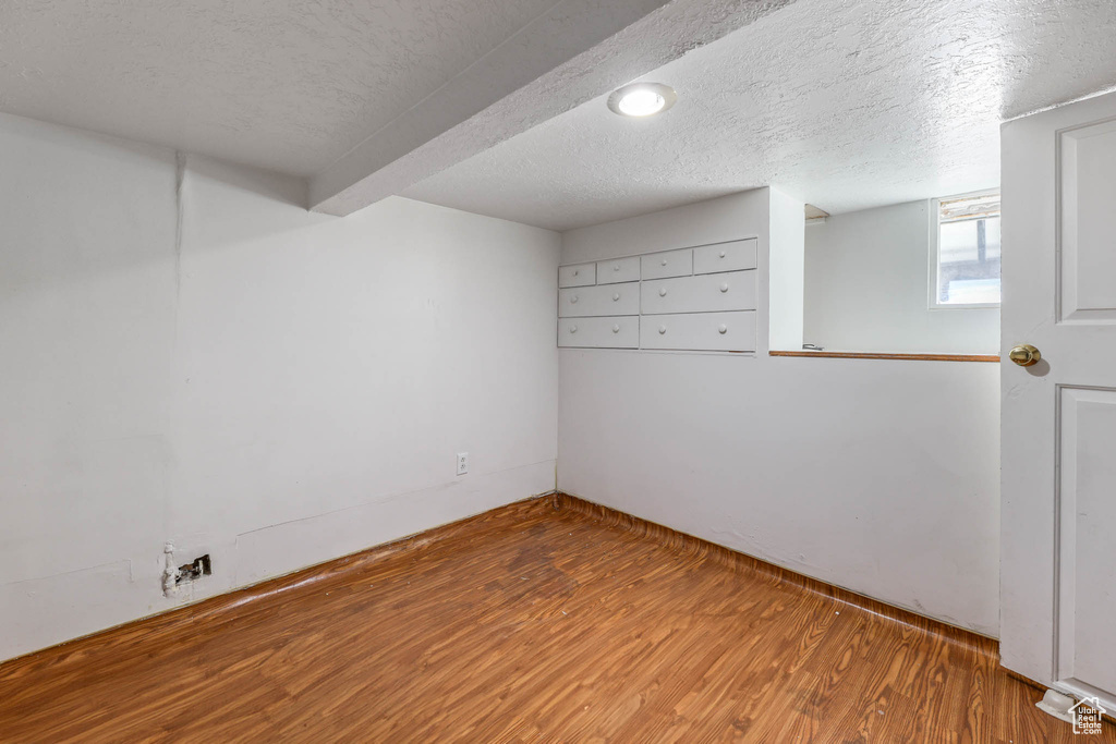 Unfurnished room with wood finished floors and a textured ceiling