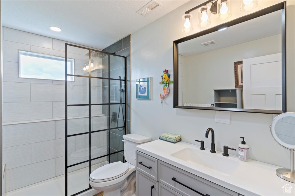 Bathroom with vanity, toilet, and a tile shower