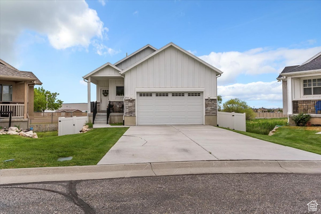 View of front of property with board and batten siding, concrete driveway, and an attached garage
