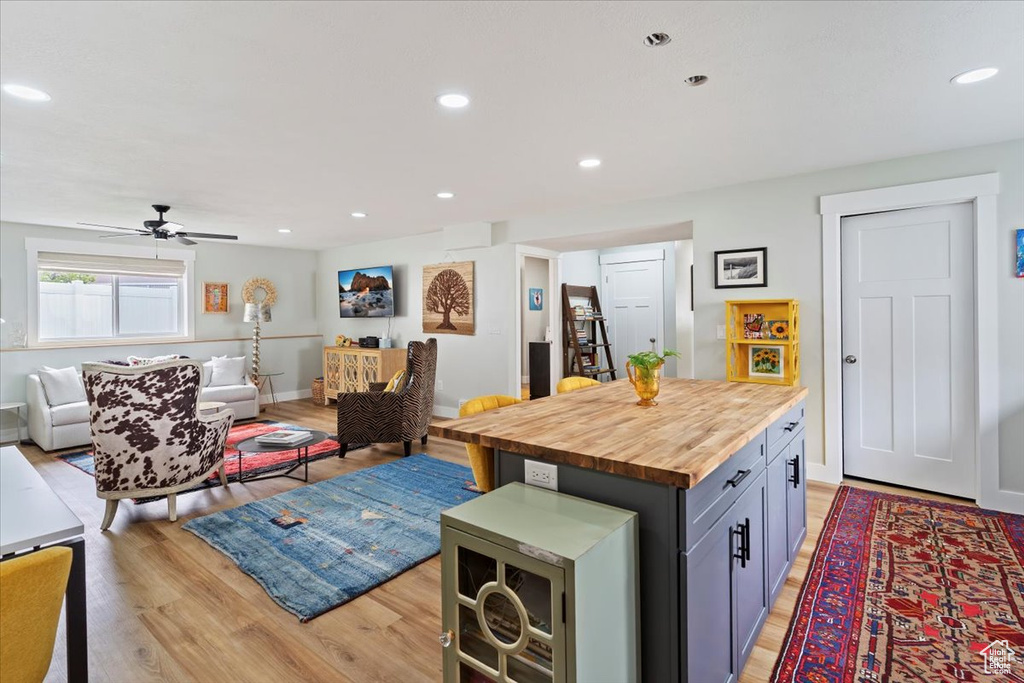 Kitchen featuring wooden counters, light wood-style flooring, open floor plan, a kitchen island, and ceiling fan