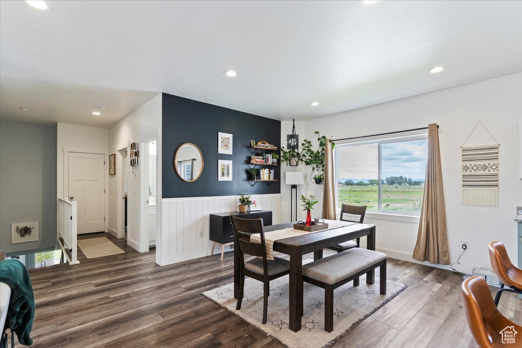 Dining space with wood finished floors, recessed lighting, and a wainscoted wall