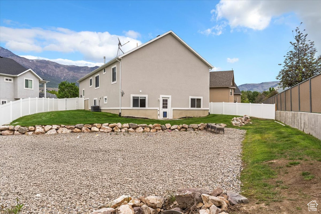 Rear view of property with a mountain view, stucco siding, and central air condition unit