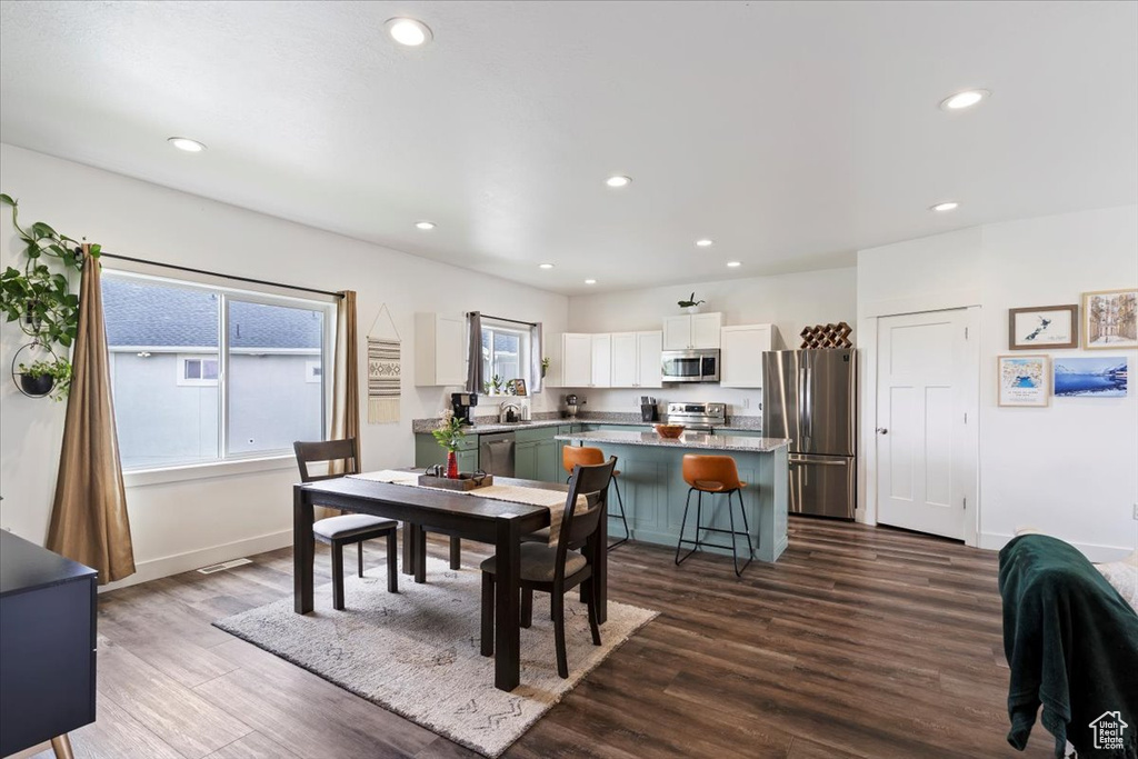 Dining room with recessed lighting, dark wood-style flooring, and baseboards