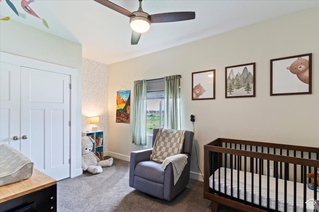Bedroom with carpet floors, baseboards, a nursery area, and a ceiling fan