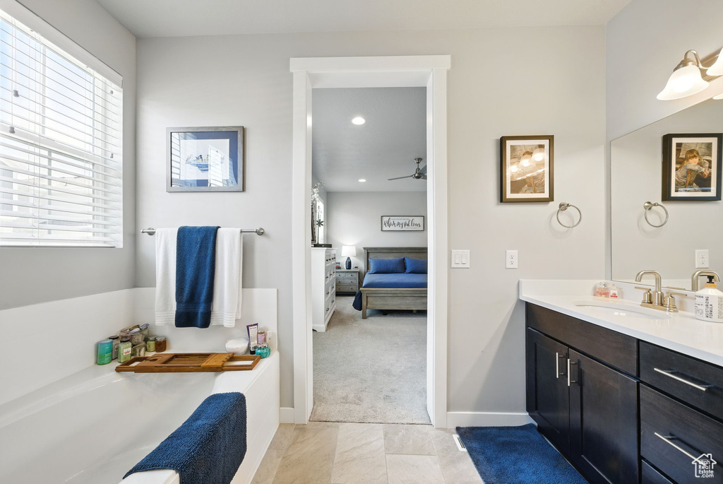 Full bathroom with connected bathroom, vanity, a bath, baseboards, and recessed lighting
