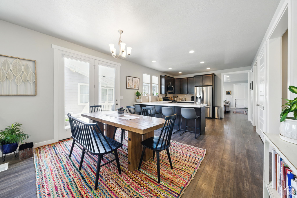 Dining area featuring a chandelier, dark wood-style flooring, recessed lighting, and baseboards