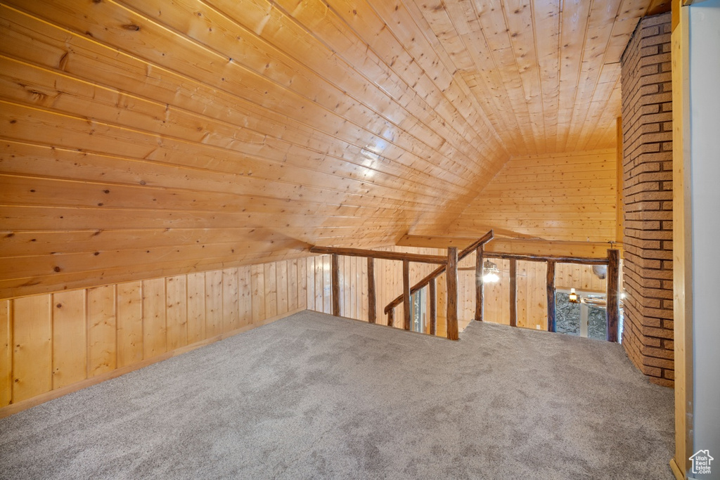 Additional living space with wood ceiling, wooden walls, carpet flooring, and lofted ceiling