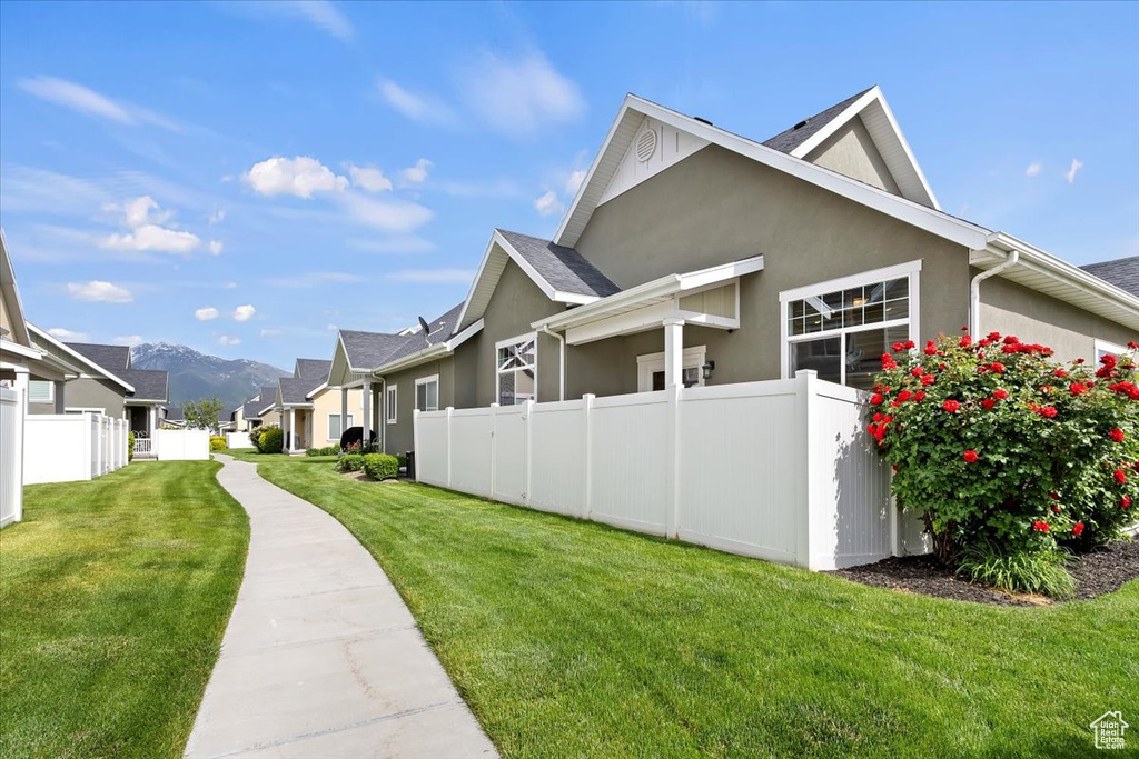 View of home's exterior with stucco siding, a residential view, and a mountain view