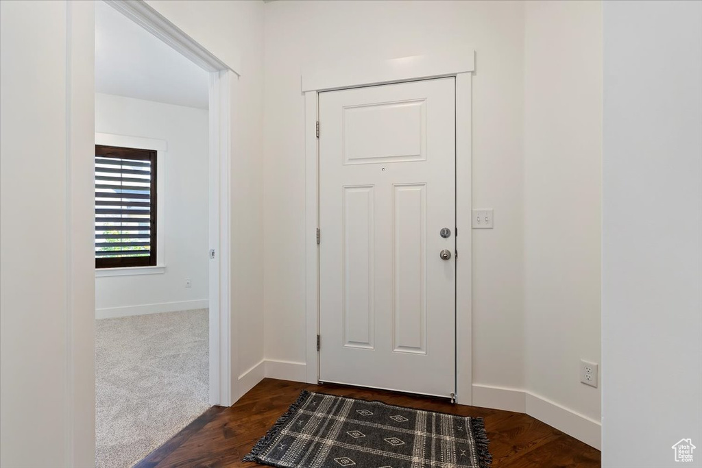 Entryway featuring baseboards and dark wood-style floors