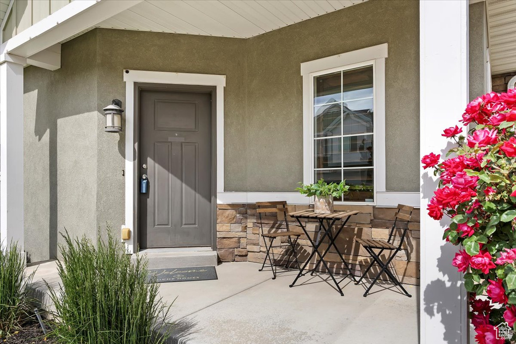 View of exterior entry featuring stucco siding and covered porch