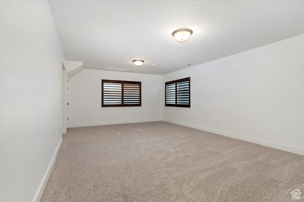 Spare room with light colored carpet and baseboards