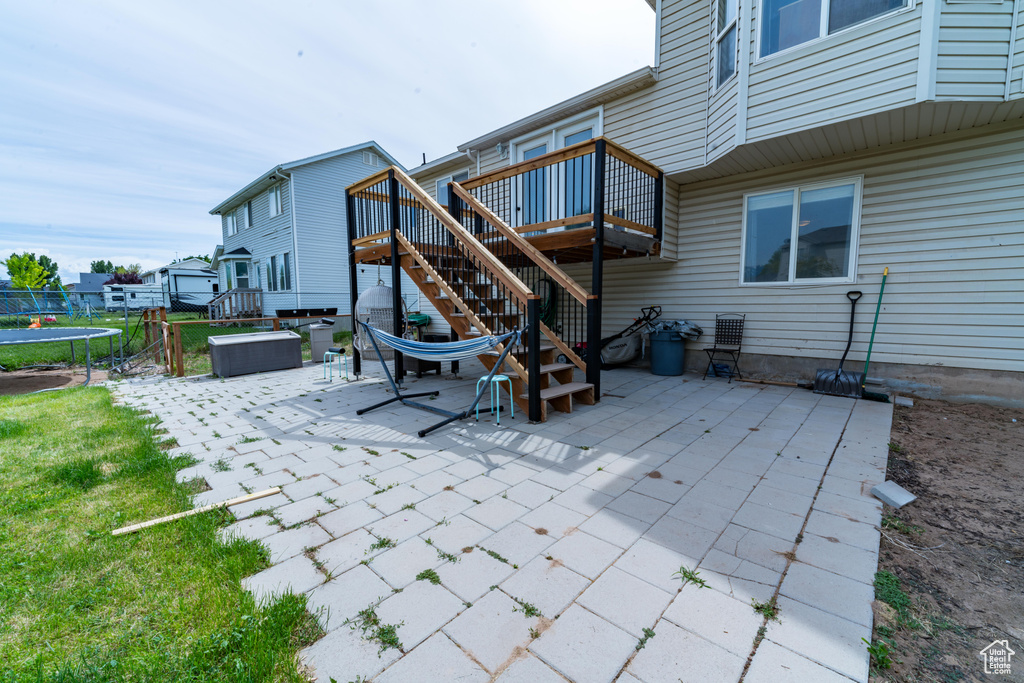 View of patio / terrace featuring a trampoline, stairway, and a deck