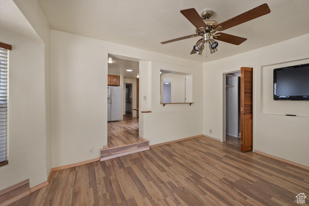 Spare room featuring wood finished floors, baseboards, and a ceiling fan
