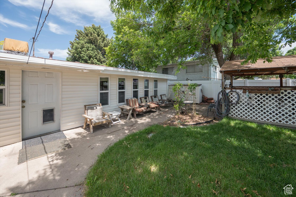 Back of property with a patio area and a lawn