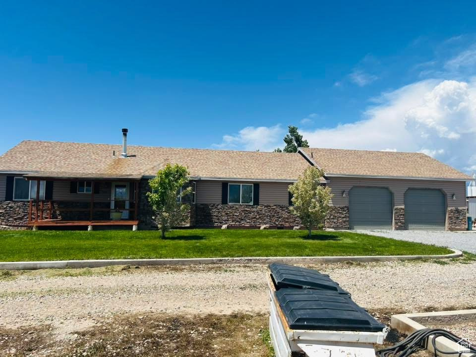 Ranch-style house featuring a front lawn and a garage