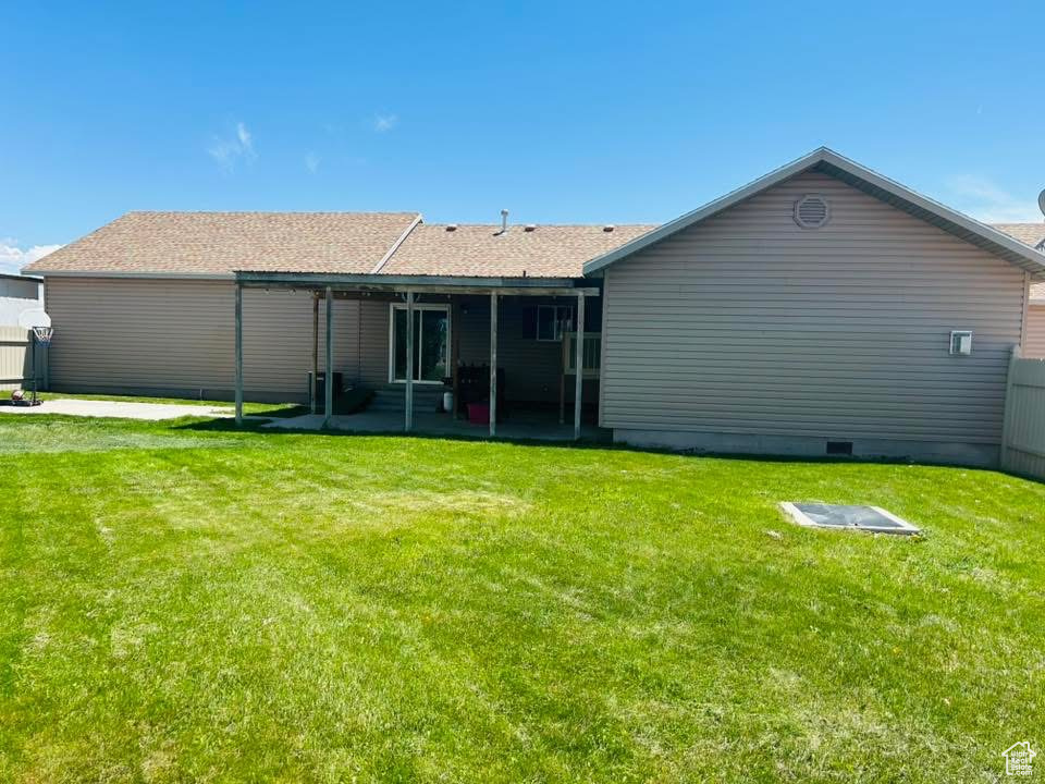 Rear view of house with a patio and a lawn