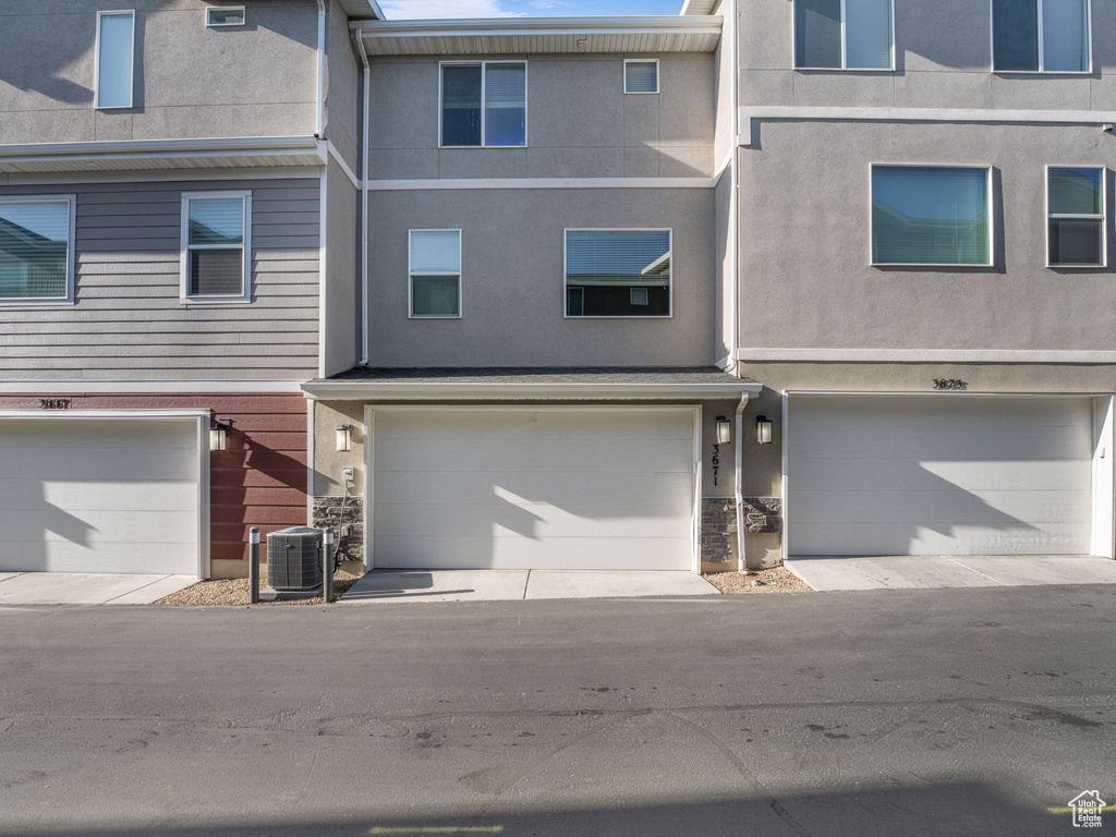 Multi unit property with an attached garage, stucco siding, central AC, and stone siding