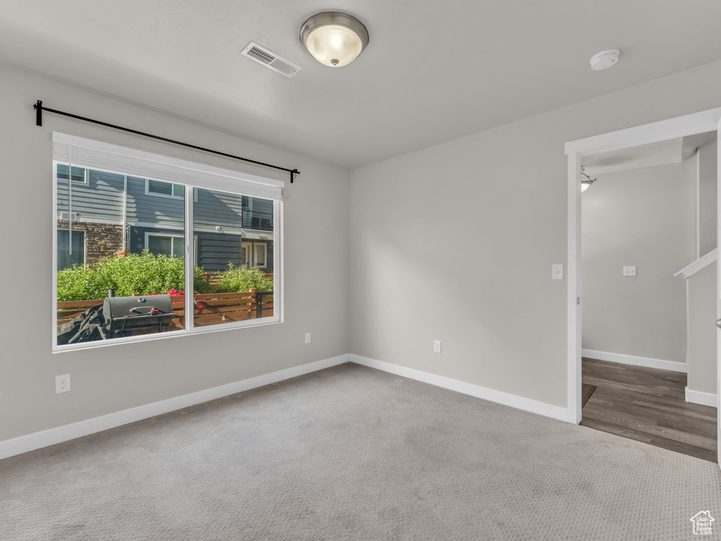 Spare room with baseboards, a smoke detector, and carpet floors