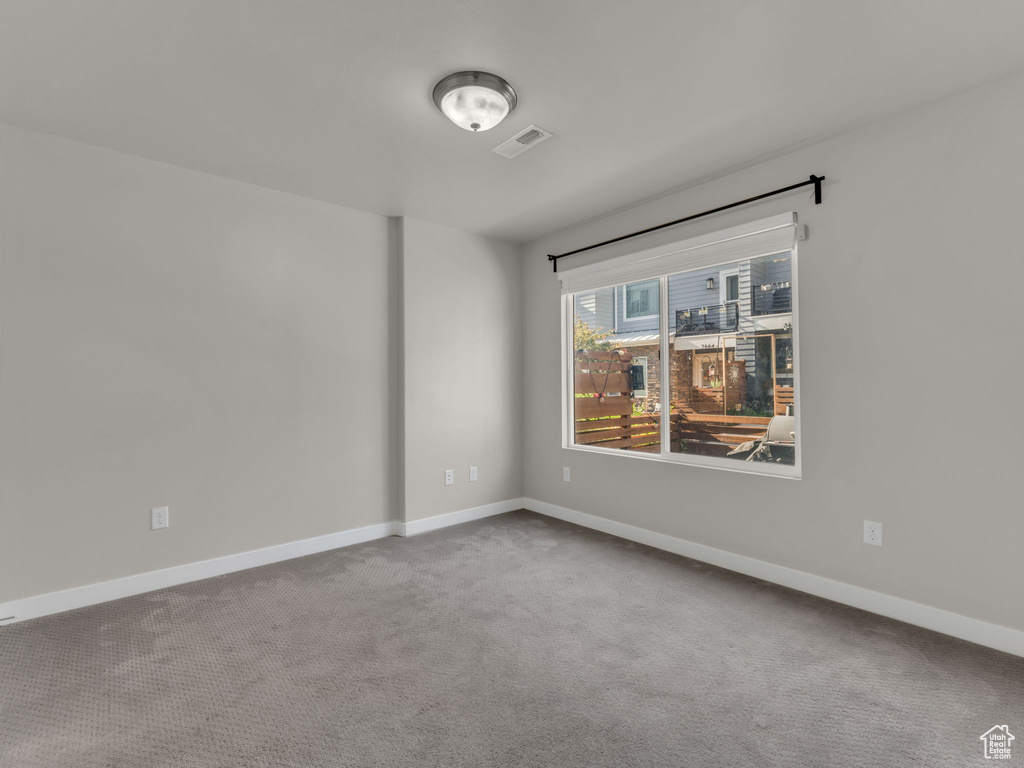 Carpeted empty room featuring baseboards