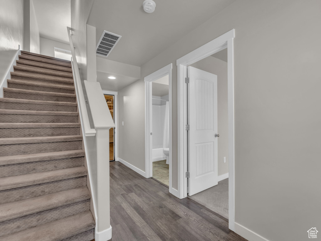 Stairs featuring wood finished floors, baseboards, and recessed lighting