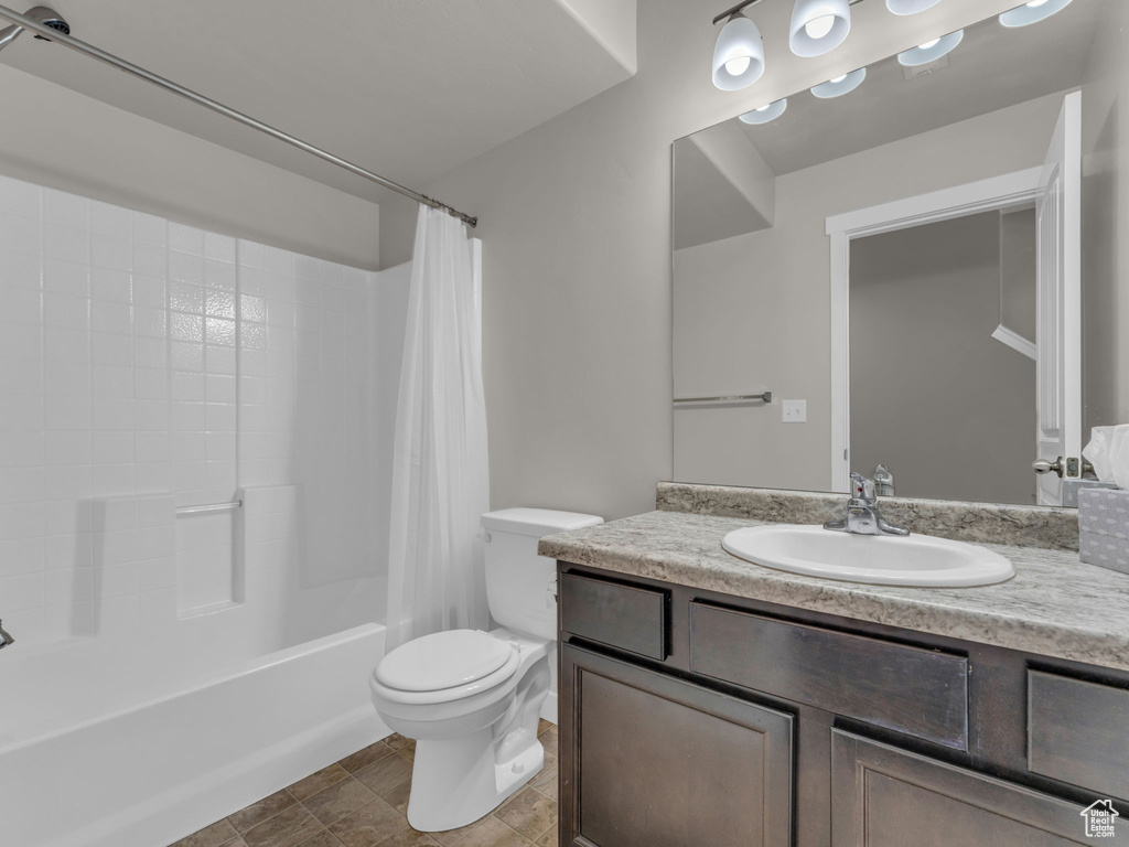 Full bath with vanity, toilet, and shower / bath combo