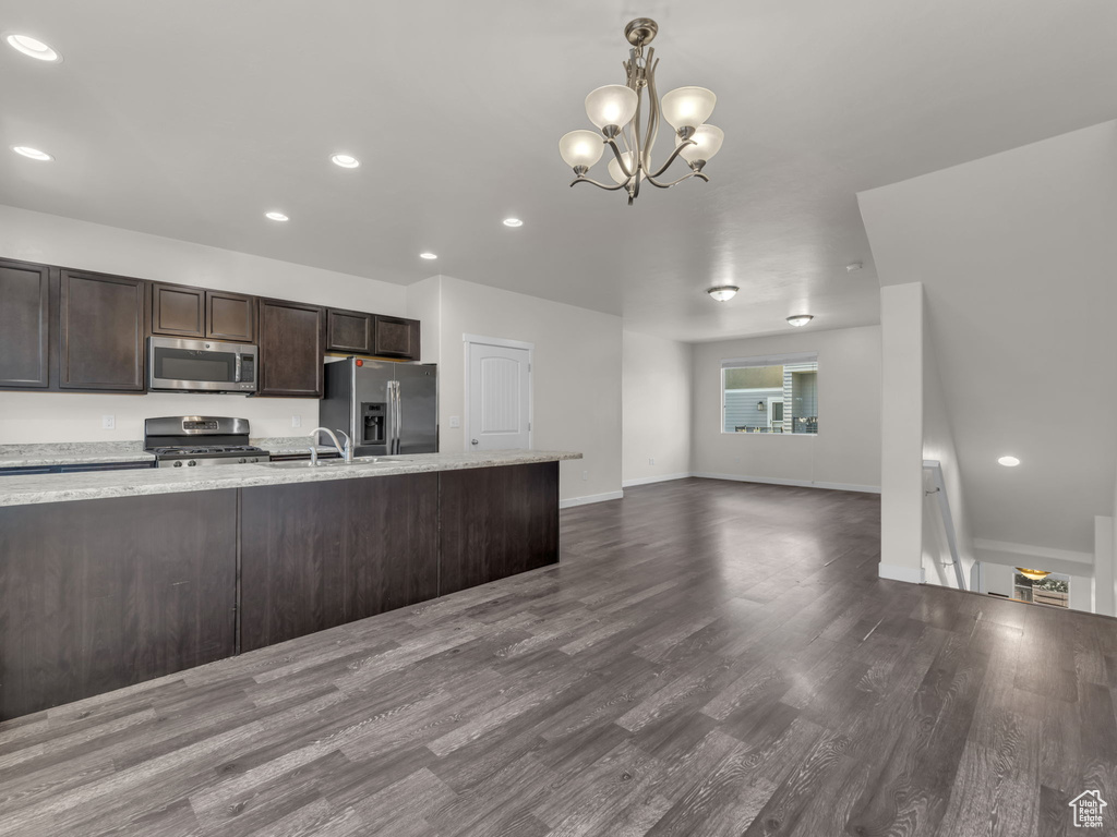 Kitchen featuring appliances with stainless steel finishes, dark brown cabinetry, dark wood finished floors, a chandelier, and recessed lighting