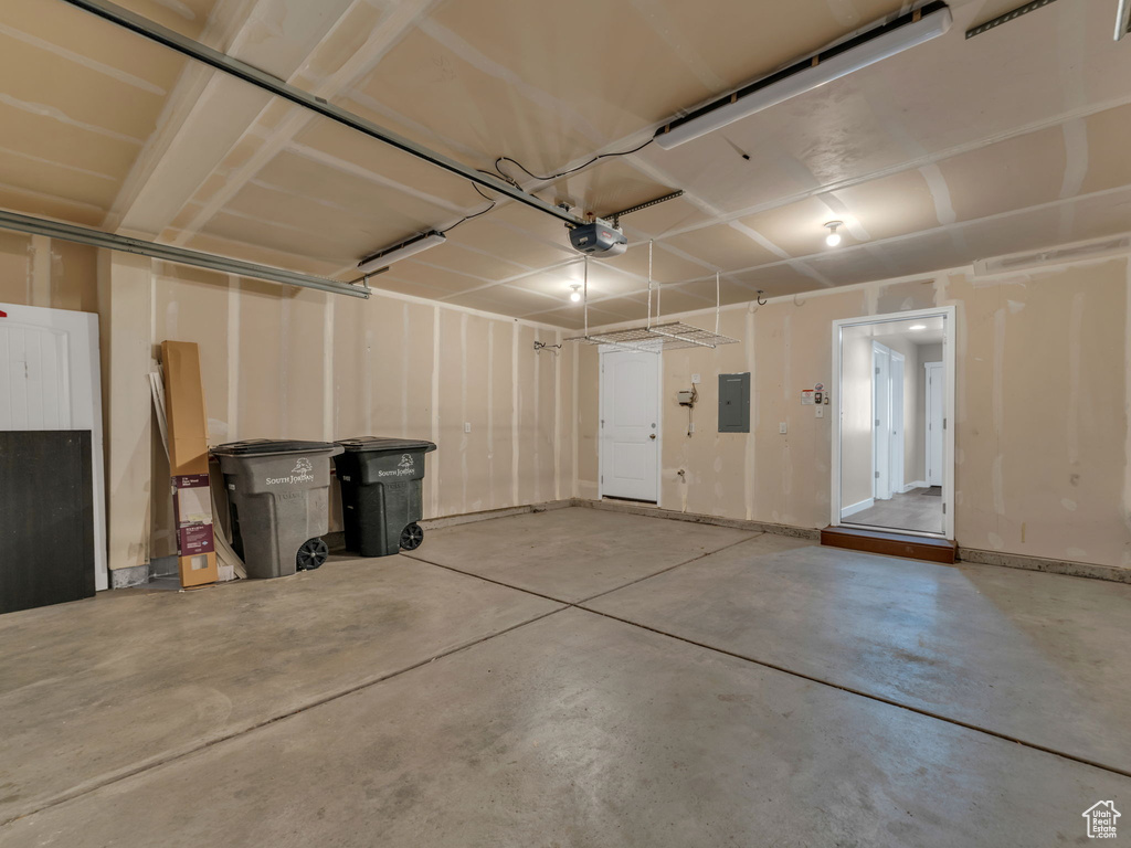 Garage featuring electric panel and a garage door opener