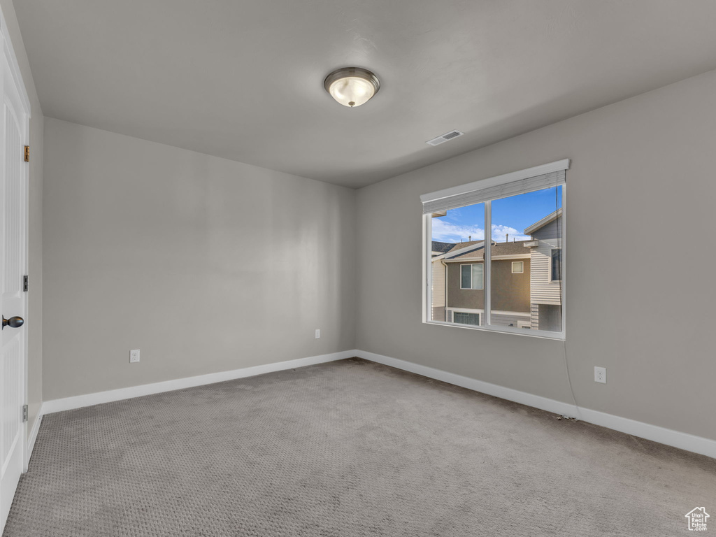 Spare room featuring baseboards and carpet flooring