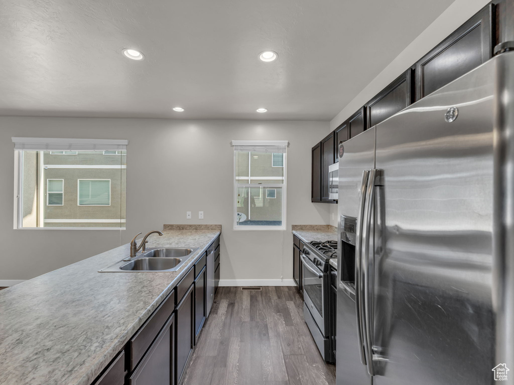 Kitchen featuring stainless steel appliances, a sink, dark wood-style flooring, recessed lighting, and light countertops