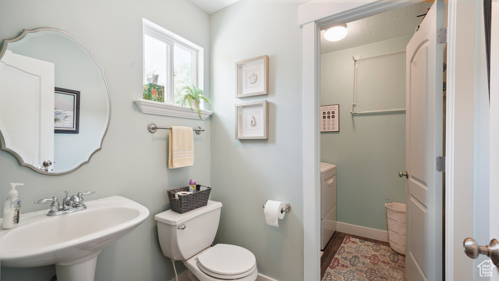 Bathroom with toilet, a sink, and baseboards